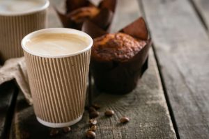 A hot latte and a muffin on a table